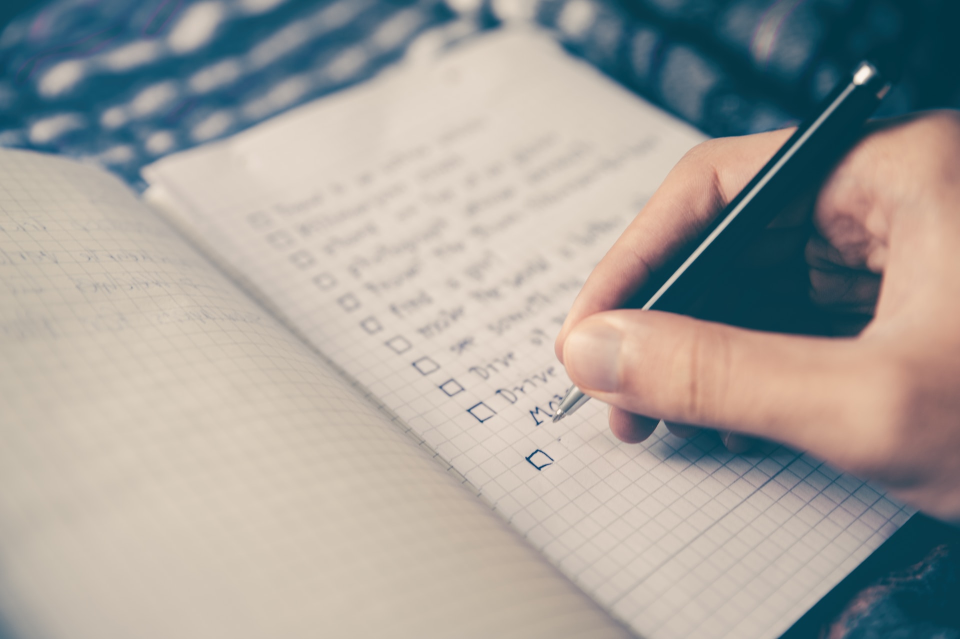 Someone writing a to-do list—there's something cathartic about handwriting a list and crossing items off, but digital productivity tools can help speed up and streamline tasks. 